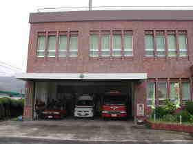 1階の車庫に3台の消防車などが並ぶ、茶色を基調とした阿久根消防署長島分遣所の外観の写真